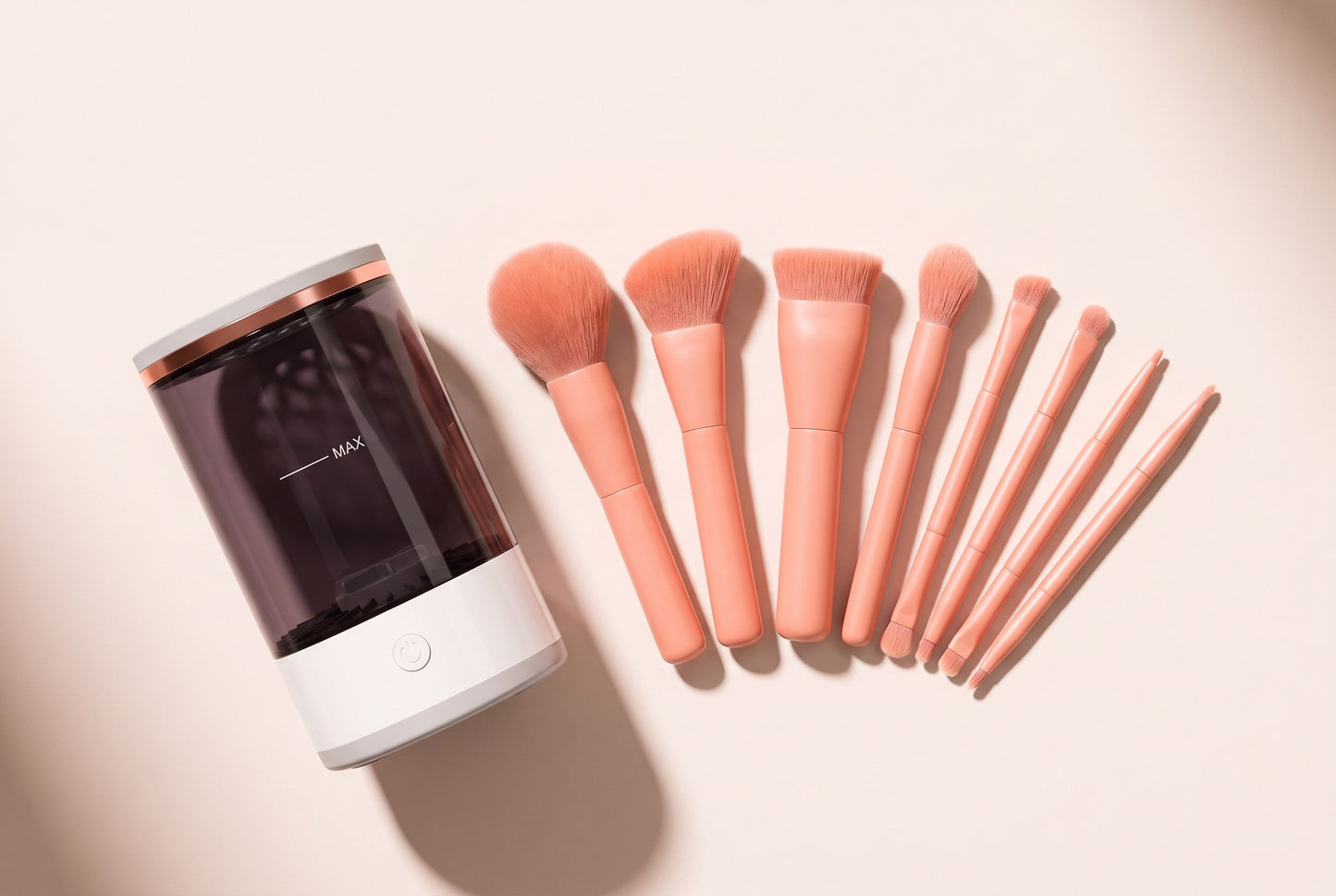The cleaner beside the ten-piece peach brush set, seen from above